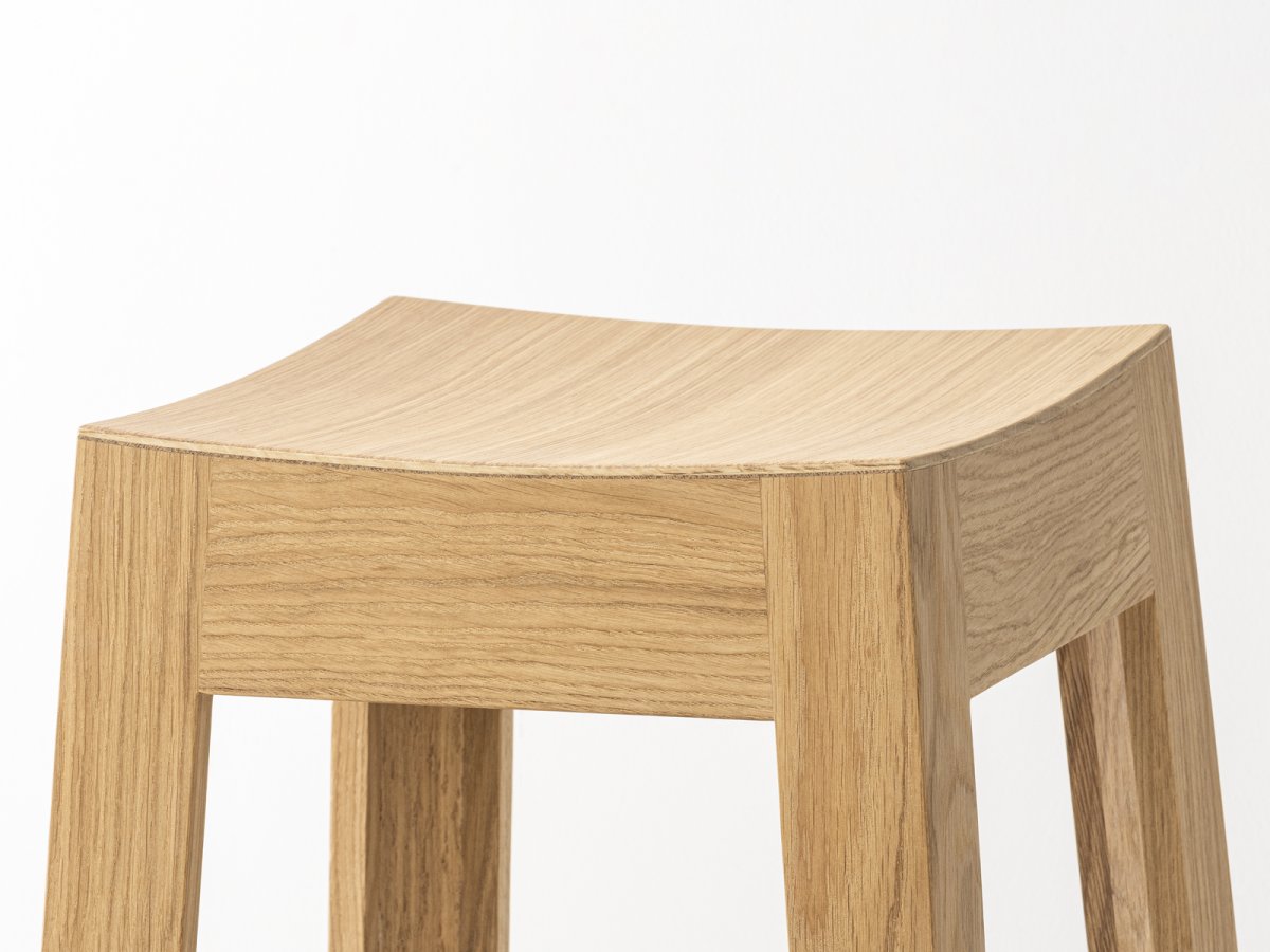 Tabouret en chêne massif doté d'une assise carrée à la forme incurvée